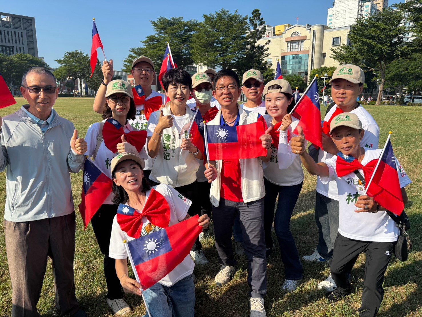 雙十國慶升旗典禮上，林建南與陳亭妃及競選團隊成員手持國旗合影。
